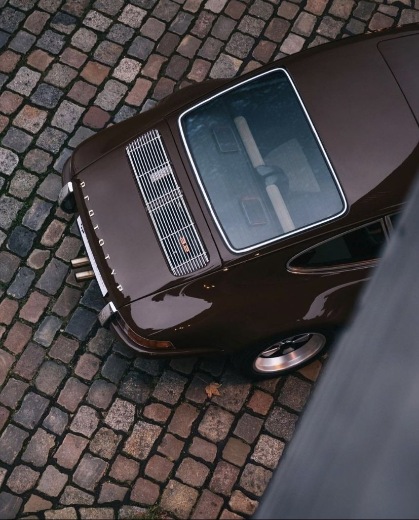Looking down into a vintage convertible with a leather duffel and wooden tennis racket on the seat